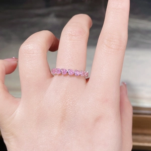 Close-up of 925 sterling silver ring with pink heart-shaped crystals on hand