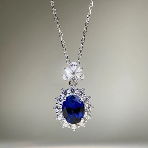 Élégant collier en argent S925 avec un grand zircon bleu ovale et un halo de pierres blanches