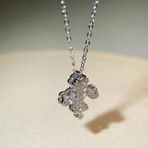 Vue macro d'un pendentif fleur de lys en argent sterling 925 avec détails ajourés rétro