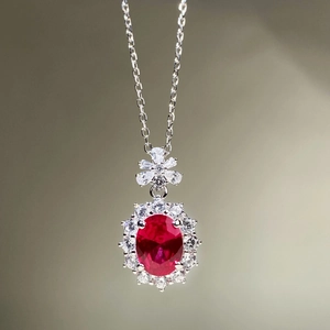 Détail macro du pendentif ovale rouge avec fermoir floral sur collier en argent s925