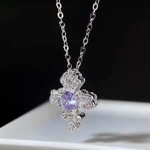 Vue macro d'un pendentif fleur de lys en argent 925 avec gemme violette et cristaux