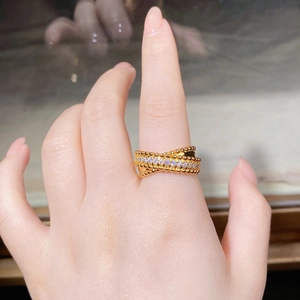 Close-up of a layered gold-plated beaded ring with sparkling zircon pavé on finger