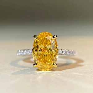 Macro shot of 5 carat yellow oval cut high carbon diamond ring with silver four-claw setting
