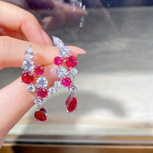 Macro shot of S925 silver earrings with teardrop red corundum and white cubic zirconia