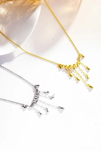 Détail de colliers à glands argentés et dorés avec perles et pendentifs en goutte