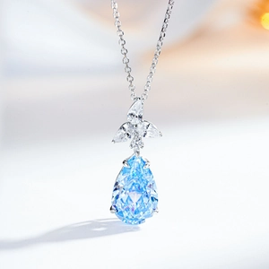 Detailed macro of pear-cut light blue gemstone pendant with white zircon accents