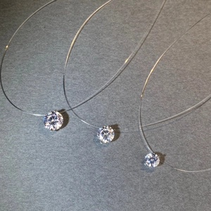 Three sizes of round brilliant cut moissanite pendants on invisible fishing line chains