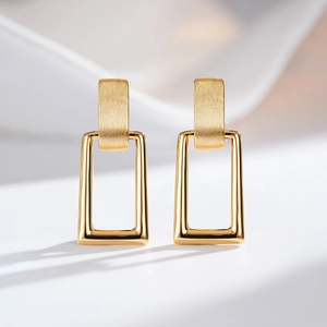 Detail of 24K gold plated earrings with brushed texture and nested geometric shapes