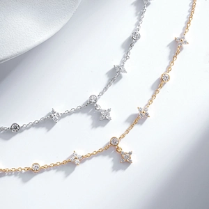 Macro view of dainty S925 silver and gold bracelets with star charms and cubic zirconia