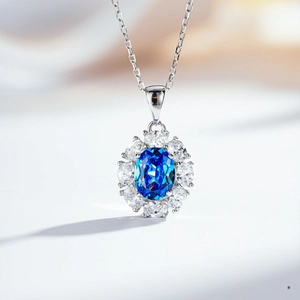 Detailed close-up of a flower-shaped silver necklace with a large oval blue gemstone
