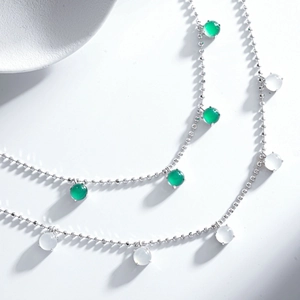 Vue macro des chaînes perlées en argent S925 avec pendentifs en calcédoine verte et blanche