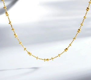Macro view of S925 sterling silver chain with 24K gold plated beads and star charms
