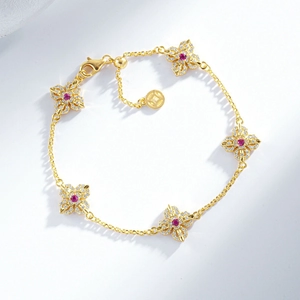 24K gold plated bracelet with five cubic zirconia pavé flowers and red center stones