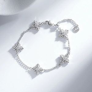 Elegant silver bracelet with five diamond-studded four-leaf clovers and adjustable chain