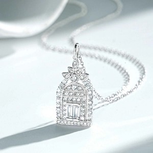 Macro detail of silver arched pendant with micro-pave diamonds and floral motif top