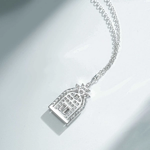 Detailed view of silver necklace with star-topped arched pendant and pavé set zircons