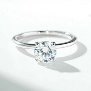 Macro view of 1 carat moissanite ring with classic four-prong setting and polished band