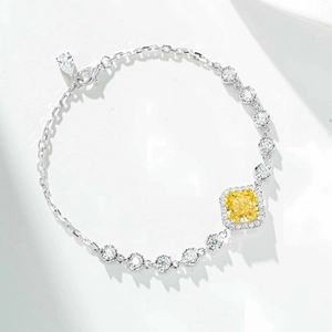 Macro view of silver bracelet with radiant cut yellow stones and halo setting details