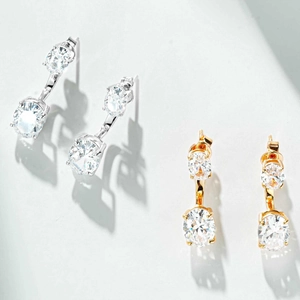 Gros plan de boucles d'oreilles pendantes en argent et or avec pierres ovales brillantes