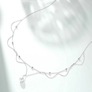Detailed macro view of S925 silver wave chain necklace with elegant white pearl pendant