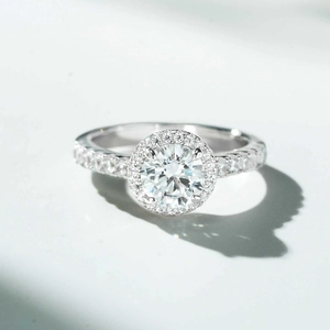 Macro shot of 1 carat round halo moissanite ring with pavé diamond setting in white gold