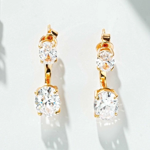 Détail de boucles d'oreilles en argent doré avec doubles diamants ovales et sertissage à quatre griffes