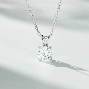 Macro detail of 1 carat round moissanite pendant with classic four-prong setting in silver