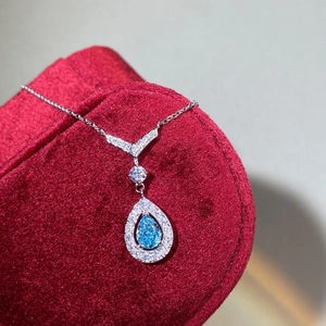 S925 sterling silver necklace featuring a teardrop blue stone pendant on red velvet