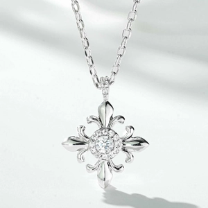 Macro detail of silver fleur-de-lis cross necklace with sparkling central gemstone