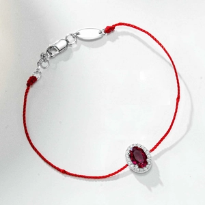 Détail du bracelet en corde rouge avec rubis ovale et fermoir en argent sterling