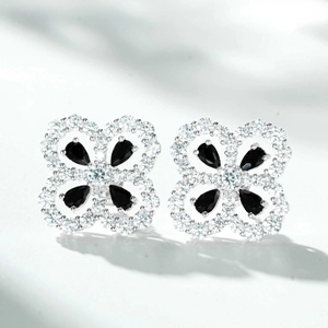 Detailed view of silver flower earrings featuring black pear-cut stones and white zircons