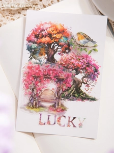 Detail of watercolor floral PET stickers featuring trees, birds, and lucky letters on a journal