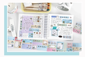 Detailed view of pastel cartoon seal washi tape and stickers on a spiral notebook