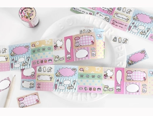 Detailed view of cartoon cat washi tape and stickers arranged on a white ceramic plate