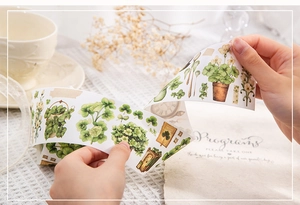 Macro view of vintage botanical washi tape showing plant illustrations and pocket watch