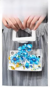 Detail of blue PET floral stickers with gold edges applied on a transparent tote bag