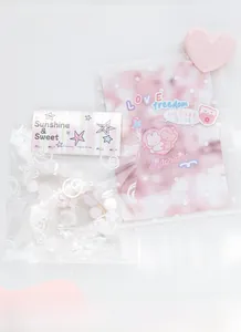 Detail of sweet beaded hair tie featuring pink shells and butterfly charms for girls