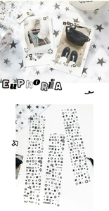 Detail of monochrome letter stickers and decorative icons with tweezers on photo albums