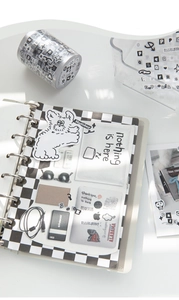 Detail of minimalist black and white decorative stickers on a checkered notebook layout