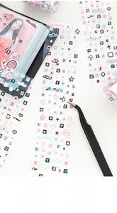 Close-up of cute macaron color die-cut stickers and heart patterns with black tweezers