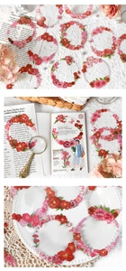 Detail of red and pink PET floral wreath stickers applied to journals and ceramics