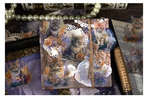 Macro detail of cat themed junk journal stickers with gold foil lines and vintage props