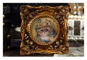 Detail view of retro gold embossed frame with vintage cat illustration and baroque patterns