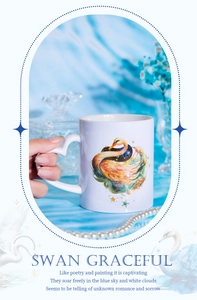 White ceramic swan mug featuring a colorful swan illustration and heart handle detail