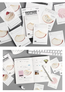 Detail van PaperMore plaknotities met appelmotieven in een notitieboek en bureau