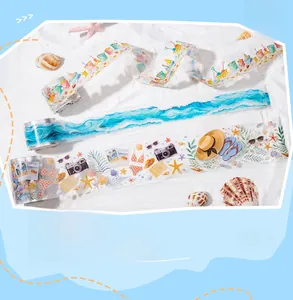 Detailed view of summer beach theme PET washi tape set on sand with shells and starfish