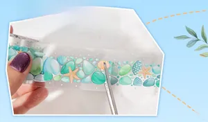 Detail of ocean theme decorative tape with sea shells and scissors for DIY scrapbooking