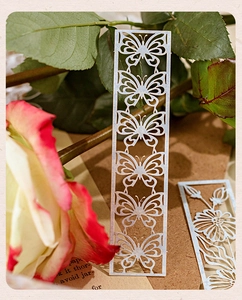 Detail of silver hollow metal butterfly bookmark on a vintage floral background