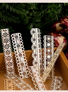Close-up of vintage hollow lace paper strips for DIY journaling in a wooden box