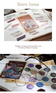 Macro detail of retro stationery stickers and wax seals on a vintage journal layout